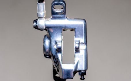 Vue frontale d’un étrier de frein Shimano XTR avec la fente des plaquettes entièrement ouverte et les pistons rétractés.