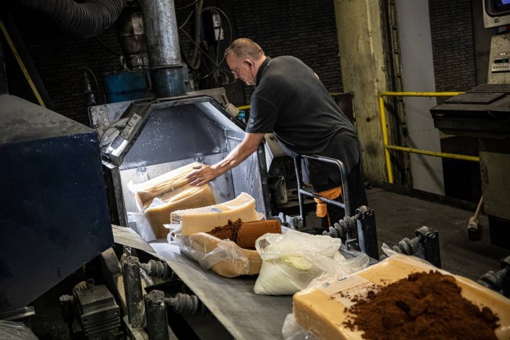 Employé dans une usine charge différentes gommes dans une machine pour la fabrication de pneus de vélo.