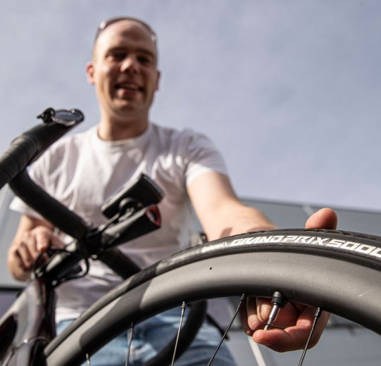 Jonas laisse échapper de l'air sur sa paire de roues tubeless.