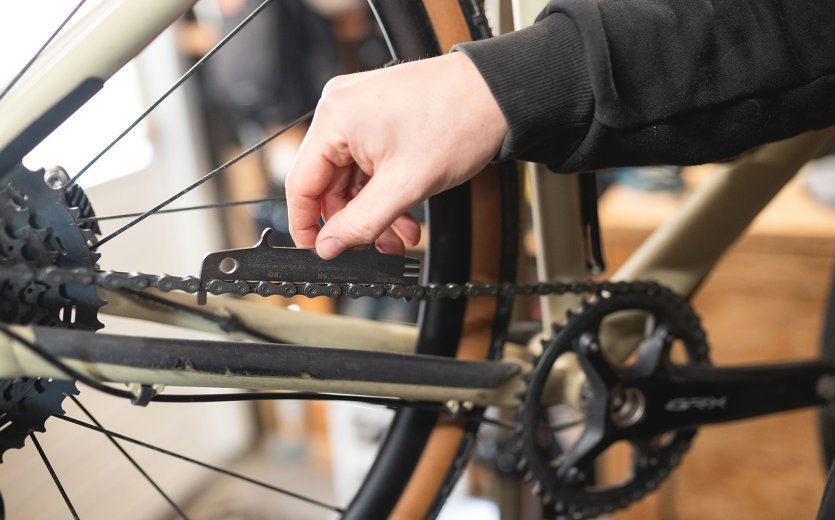 bc Mechanic Pascal checks the amount of chain stretch with a chain wear gauge. 