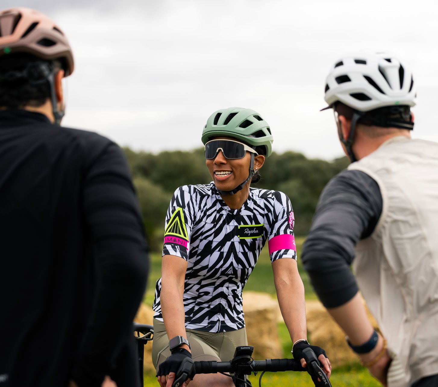 Three road cyclists wearing Lazer Blade KC helmets during a group ride break in the countryside.