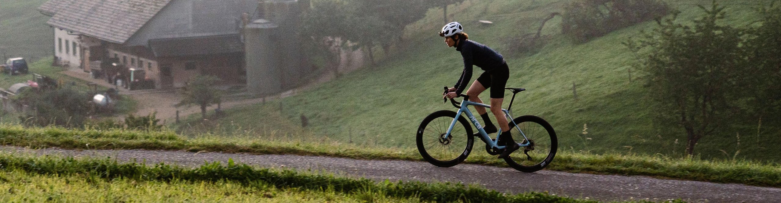 ARC8 ESCAPEE DB ULTEGRA Di2 Rennrad in Ice Blue im Einsatz auf einer ruhigen Landstraße – modernes Carbon Rennrad für Performance, Geschwindigkeit und lange Ausfahrten in anspruchsvollem Terrain.