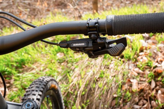 En el extremo derecho del manillar de una MTB está montado el controlador mecánico de una transmisión SRAM Eagle.