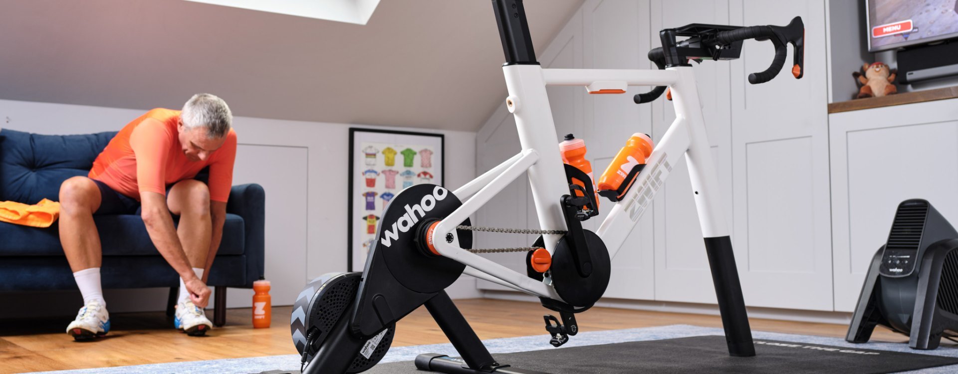Persona preparándose para una sesión de ciclismo indoor junto a una bicicleta inteligente Wahoo.