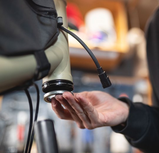 bc Mechanic Pascal inserts the lower bearing of a headset.