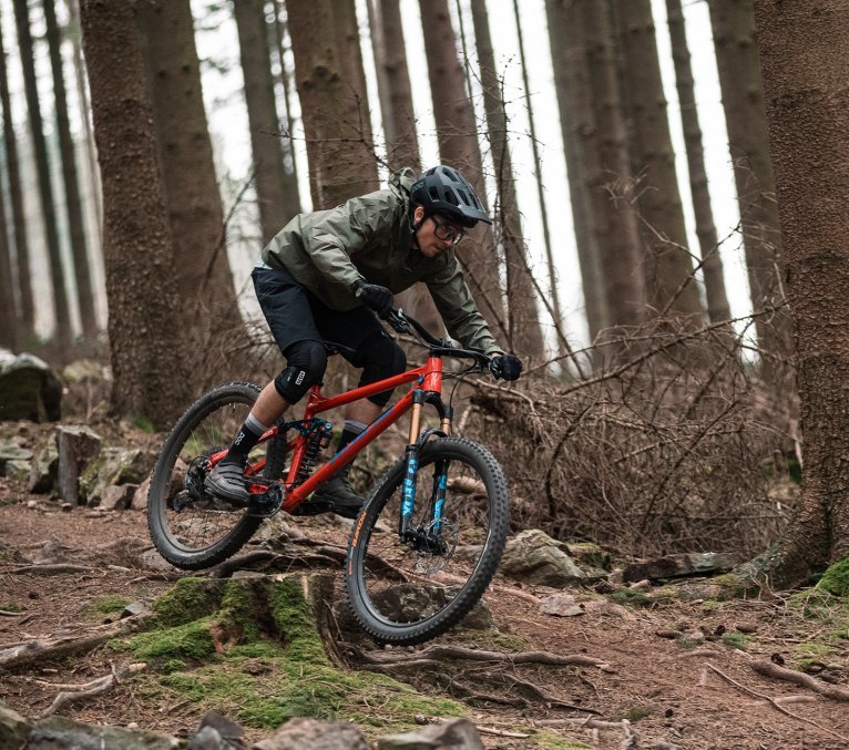 Mountainbiker fährt Trail im Wald in Winterbekleidung