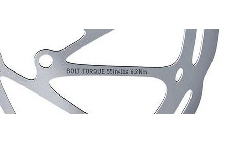 Gros plan sur un disque de frein de vélo portant l’indication “Bolt Torque 55 in-lbs / 6.2 Nm”.
