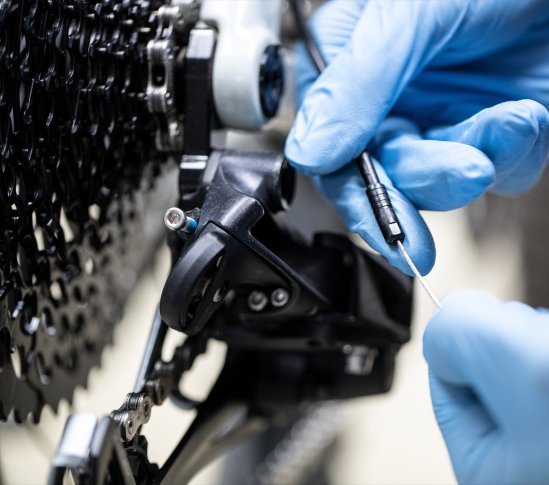 Der Mechaniker prüft die Reibung des Schaltzugs in der Außenhülle.