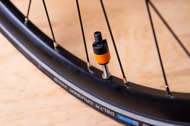 Close-up: A Clik Valve pump adapter is attached to a mounted bicycle valve.