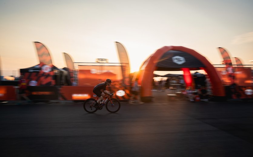Rennradfahrer fährt am bc Camp bei Sonnenuntergang vorbei