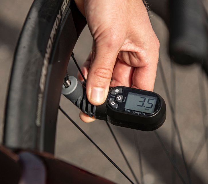 Jonas from bc Product Management checks the air pressure of his tyre with a digital measuring gauge.