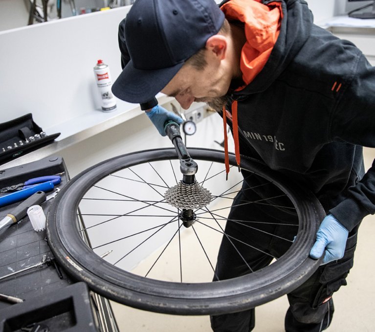 Thomas, mécanicien chez bc, serre une nouvelle cassette sur la roue libre à l’aide d’une clef dynamométrique.