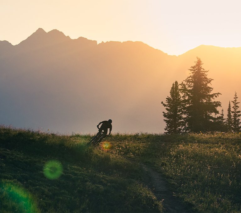 Mountainbiker lehnt sich bei Sonnenuntergang in die Kurve