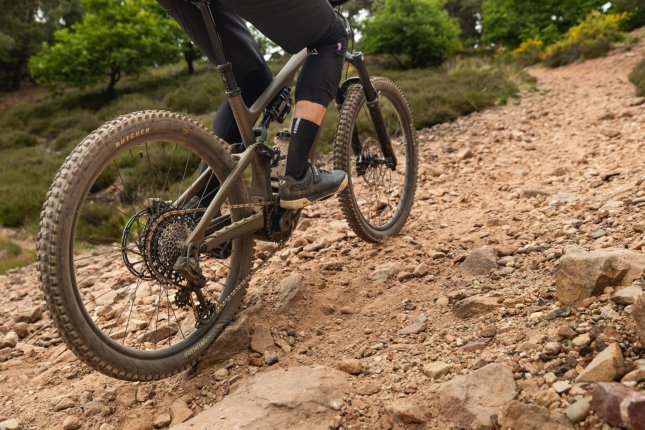 Detailfoto: Ein Turbo Levo 4 fäht bergauf über einen geschotterten Trail.