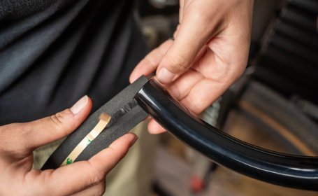 Die Mechanikerin setzt das Lenkerband so an, dass ein Drittel bis die Hälfte des Lenkerbandes übersteht.