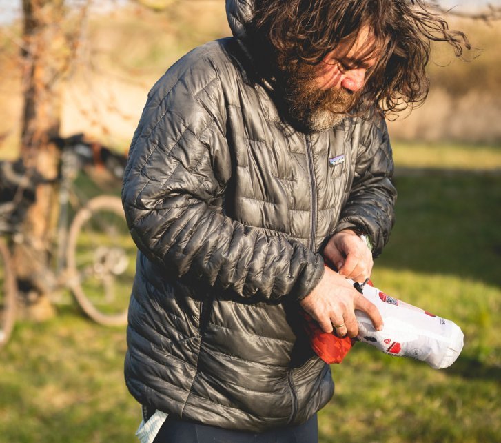 Christian, du service clientèle de bike-components, range son matelas de camping dans sa housse.