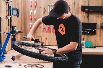 Zweiradmechaniker Pascal installiert im bc Werkstattstudio eine Kassette an ein Laufrad.
