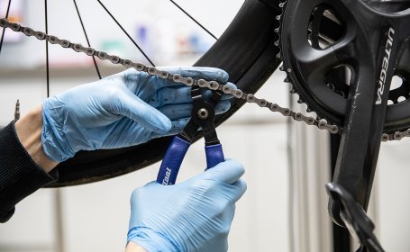 bc Mechanic Thomas opens the master link of a road bike chain.