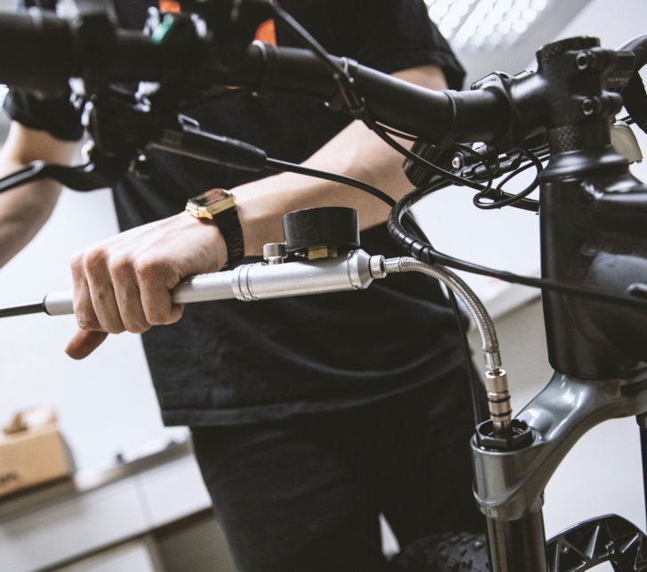 A bc mechanic optimises the suspension stiffness on an MTB using a suspension fork and shock pump.