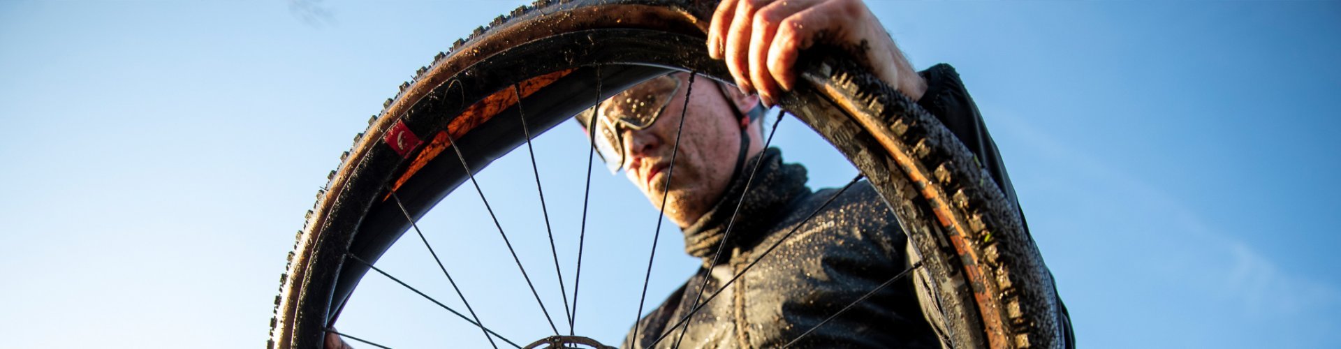 A biker installs a new tube between the rim and tyre of his gravel bike after a puncture.