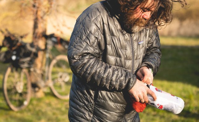 Christian, du service clientèle de bike-components, range son matelas de camping dans sa housse.