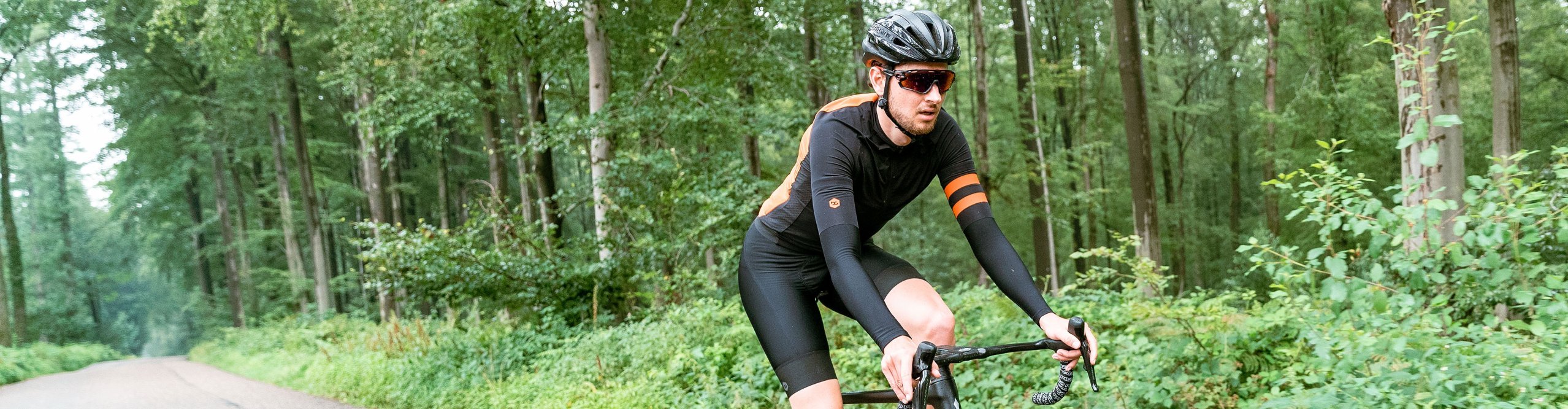 bc Rennradfahrer fährt im Wald mit Vibe Evo Lenker